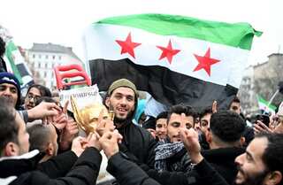 Syrians topple and trample on statues of Assad's father