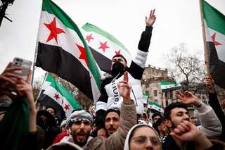 Armed men escort Syrian PM to hotel after Bashar al-Assad flees country