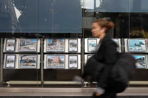 A pedestrian walks past resdiential properties displayed for sale in the of an estate agents' in London on September 30, 2022. 