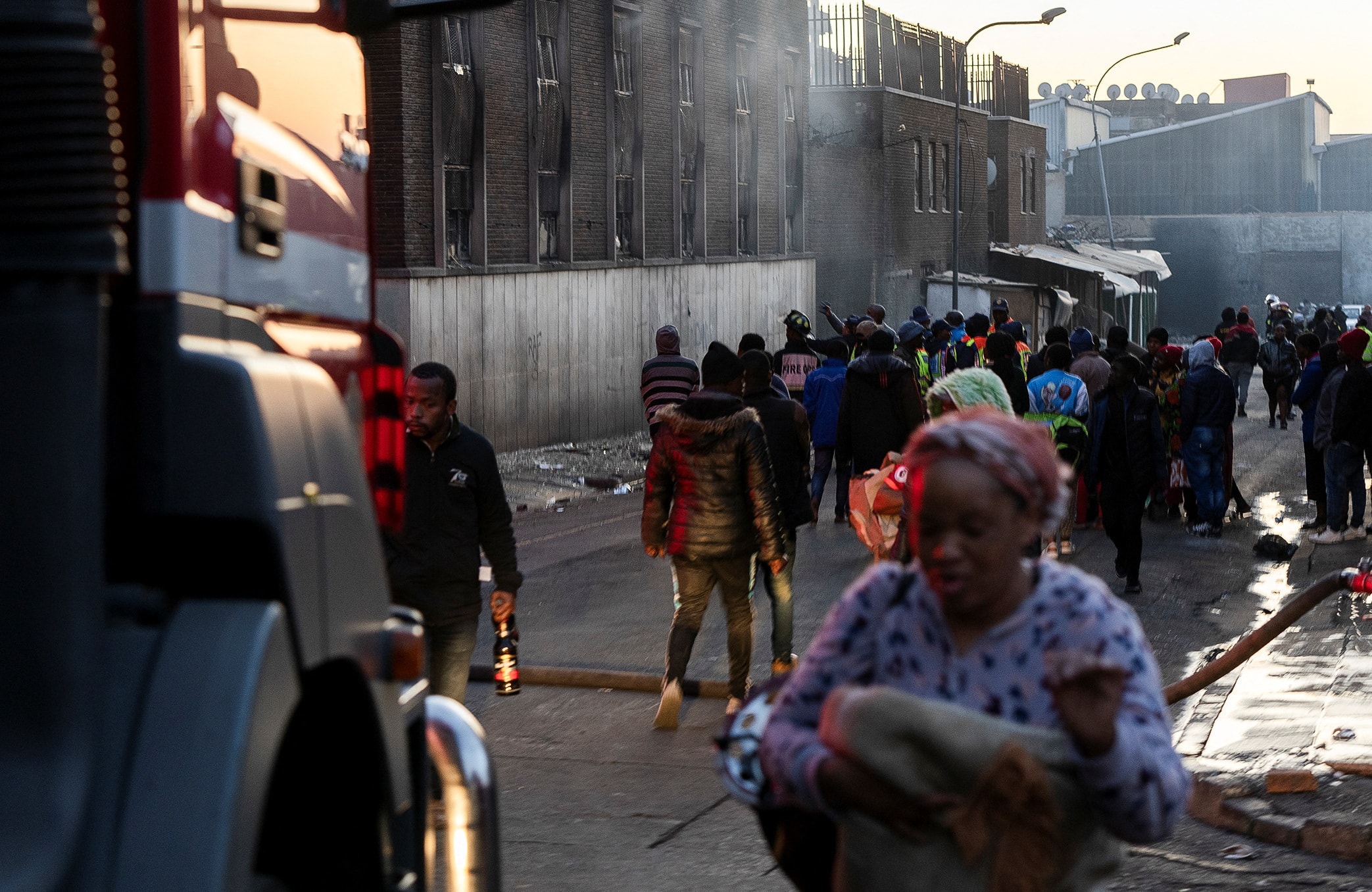 People walk past the 5-storey building after a deadly blaze on August 31, 2023.
