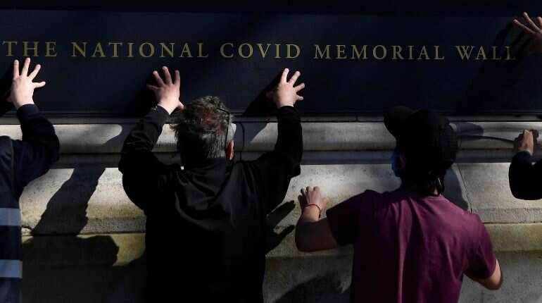 Volunteers and relatives of bereaved paint hearts along a wall beside St Thomas' hospital as a memorial to all those who have died so far in the UK from COVID-19, amid the spread of the coronavirus disease pandemic in London, Britain, March 29, 2021