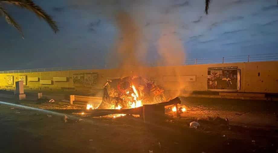 Burning debris are seen on a road near Baghdad International Airport