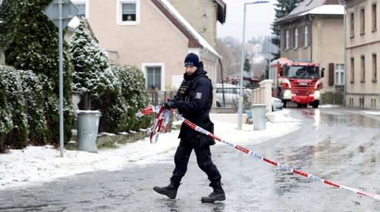A police officer cordons off the area next to a home for people with disabilities which was affected by a fire in Vejprty