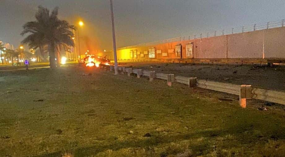 Burning debris are seen on a road near Baghdad International Airport