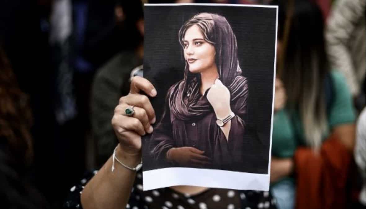 A protester holds a portrait of Mahsa Amini during a demonstration in her support in front of the Iranian embassy in Brussels | AFP