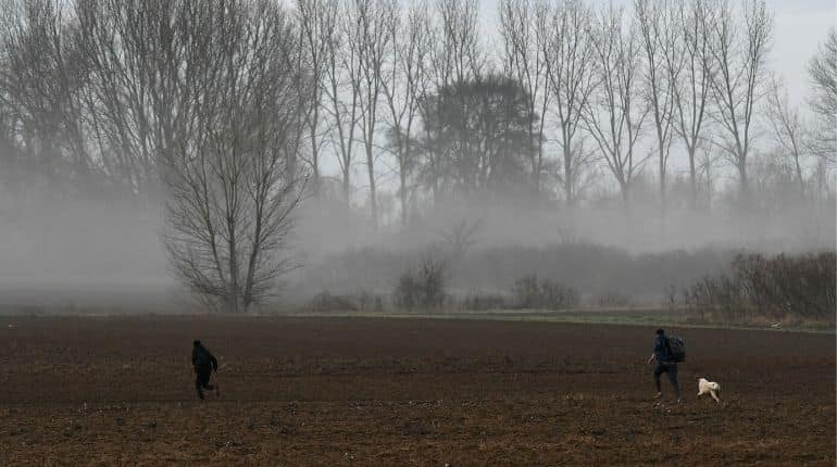 Two migrants who crossed the border from Turkey to Greece run through a field, near the town of Soufli, in the region of Evros, Greece