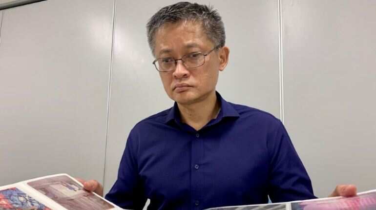 Former Hong Kong student leader Chan Ching-wah looks at an album with photos he and his friends took during their trip to Beijing in 1989, as he poses for the camera in Hong Kong, China June 1, 2020