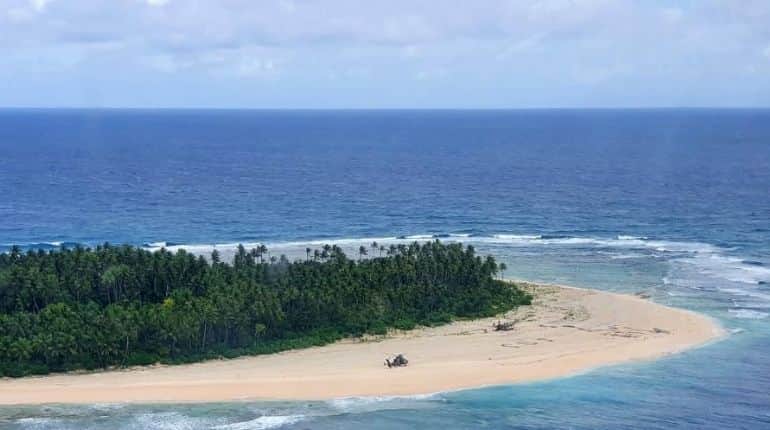 This handout photo taken on August 2, 2020 and received on August 4 from the Australian Defence Force shows an Australian Army ARH Tiger helicopter landing near the letters "SOS" (C) on a beach on Pikelot Island where three men were found in good condition after being missing for three days. Three Micronesian sailors stranded on a tiny island in the remote Western Pacific were rescued after Australian and US warplanes spotted a gian