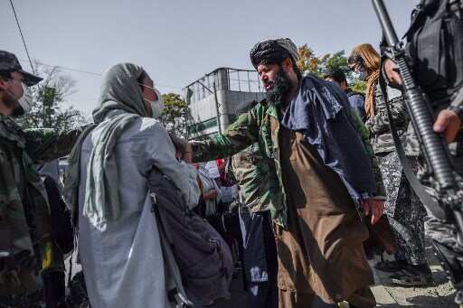 Taliban members stop women protesting for women's rights in Kabul on October 21, 2021