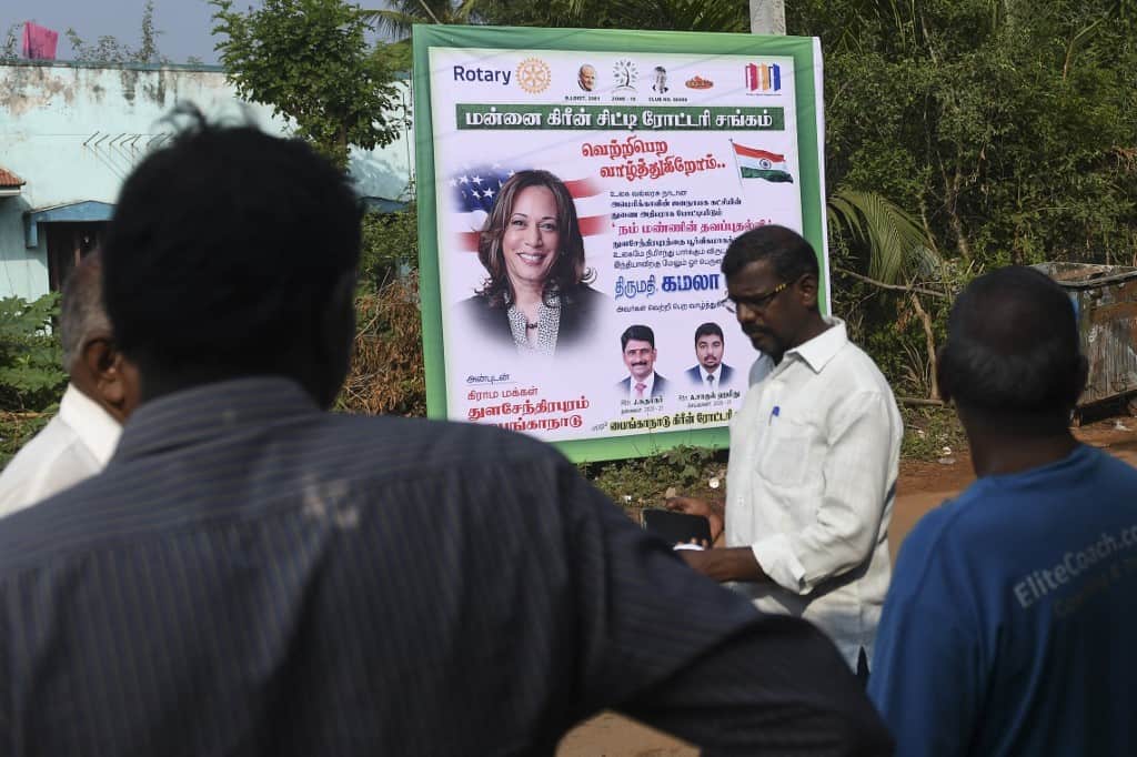 Residents walk past a poster of Kamala Harris at her ancestral village of Thulasendrapuram in the southern Indian state of Tamil Nadu on November 3, 2020 - AFP Photo