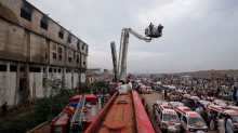 Ambulances and fire brigade vehicles outside a building, after a fire at a garment factory in Karachi September 12, 2012.
