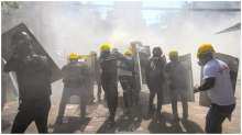 A file photo of protesters reacting after tear gas was fired during a demonstration against the military coup in Yangon. 