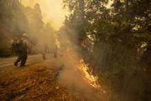 Firefighters tend to a backfire set to battle the Windy Fire on September 25, 2021 south of California Hot Springs